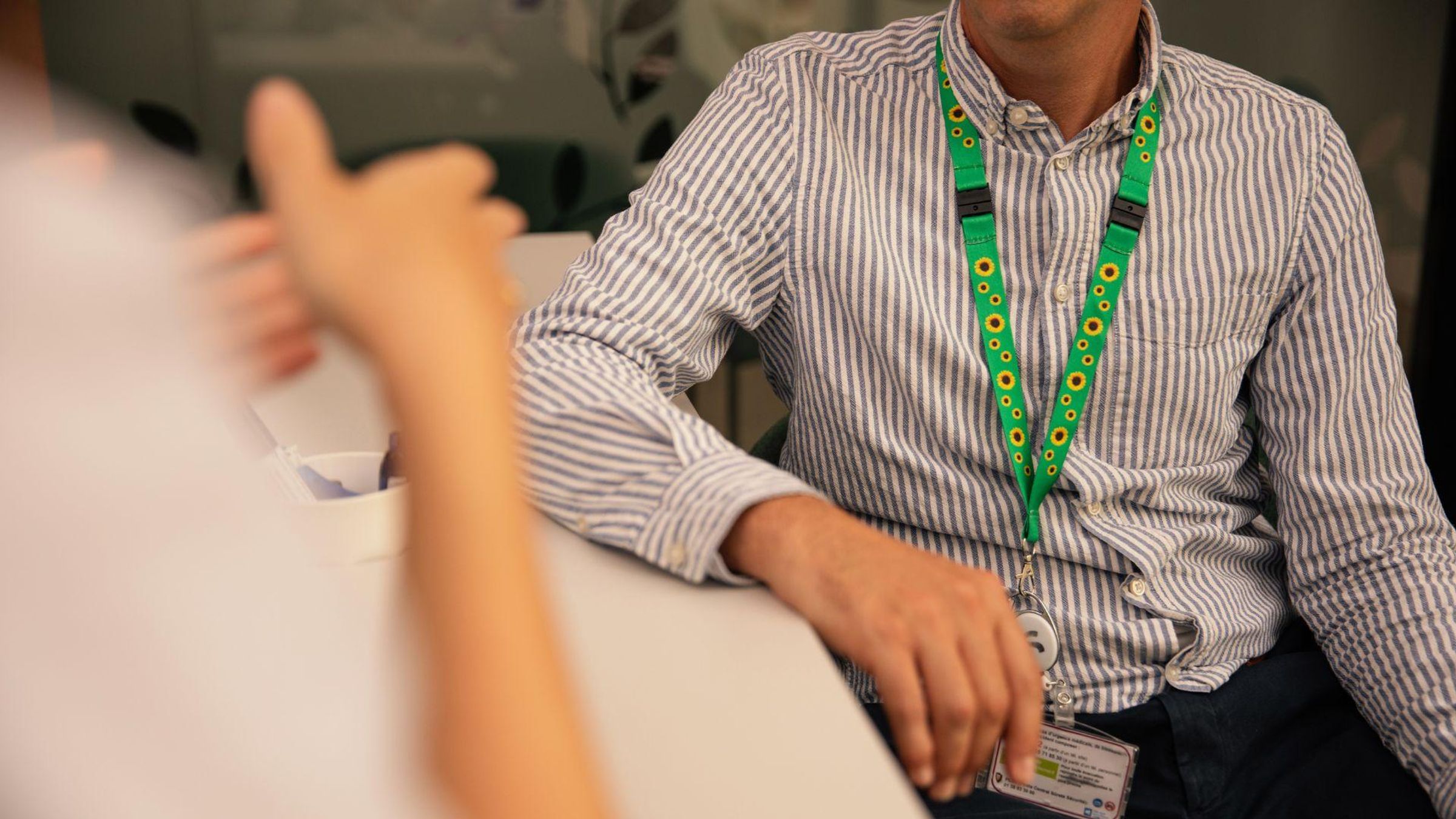 Patient wearing a sunflower lanyard indicating an invisible disability during a medical consultation with a healthcare professional.