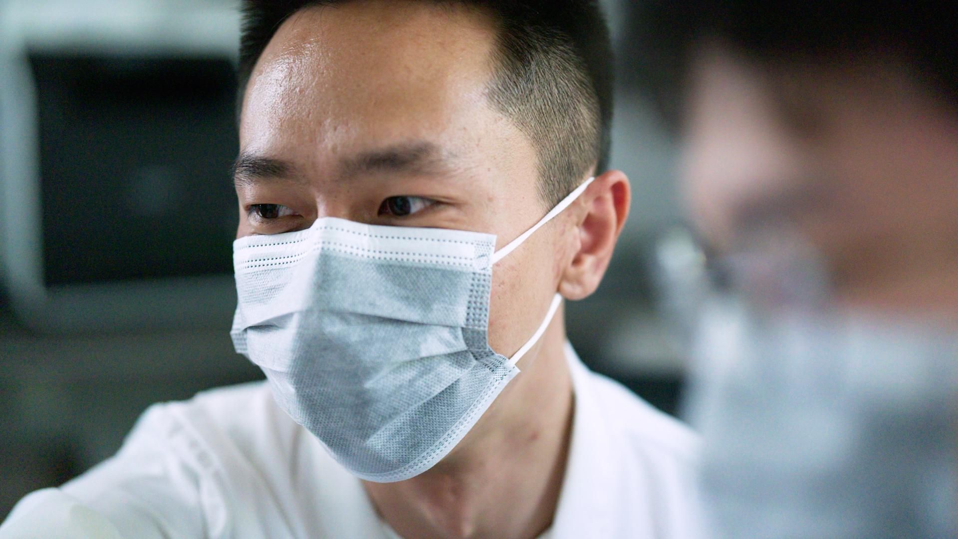 Young man on park bench with subtitle from video: 'Watching my grandmother fade away from Alzheimer's